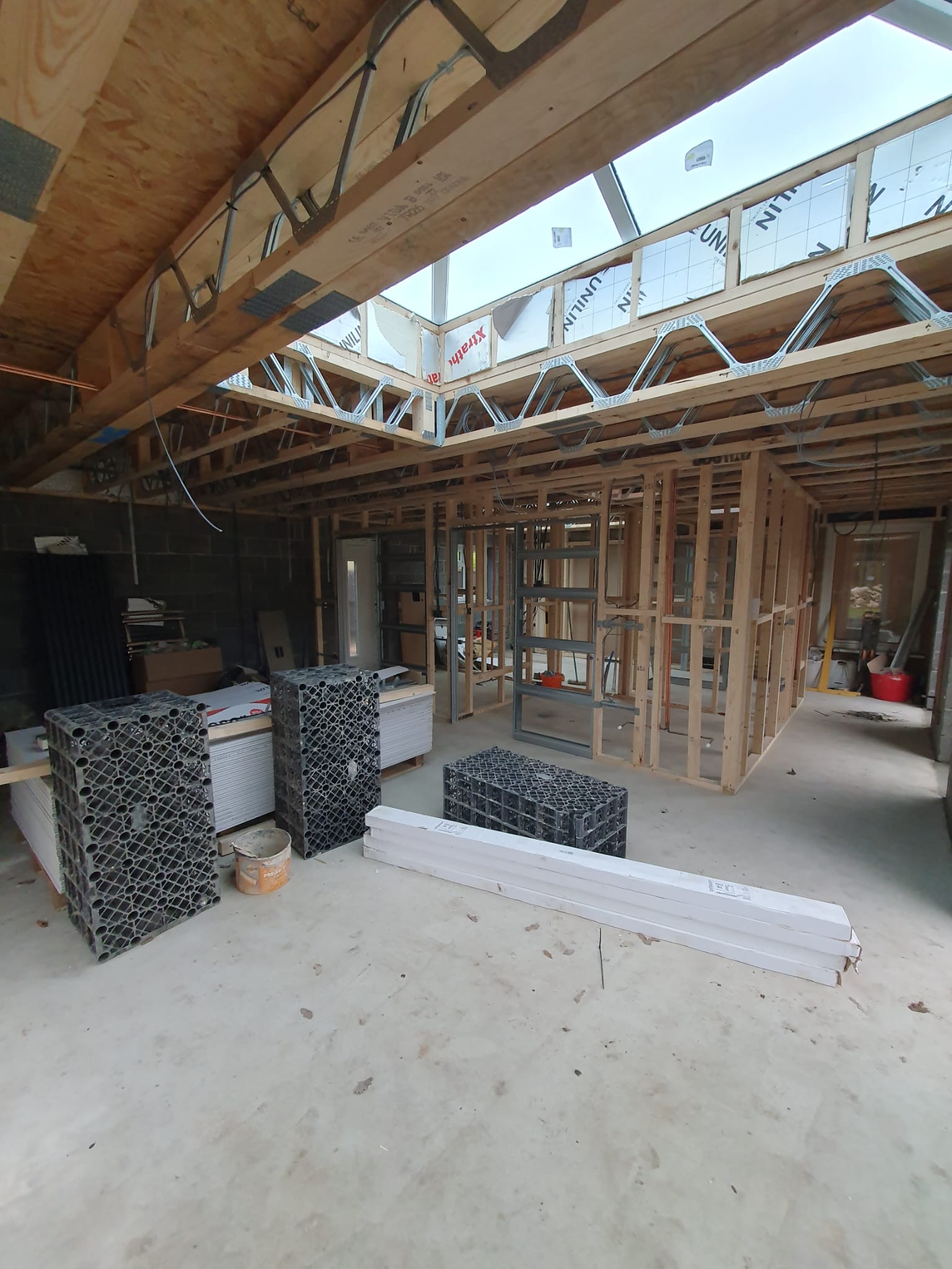 Open extension shell with timber trusses, rooflights and first-fix cabling