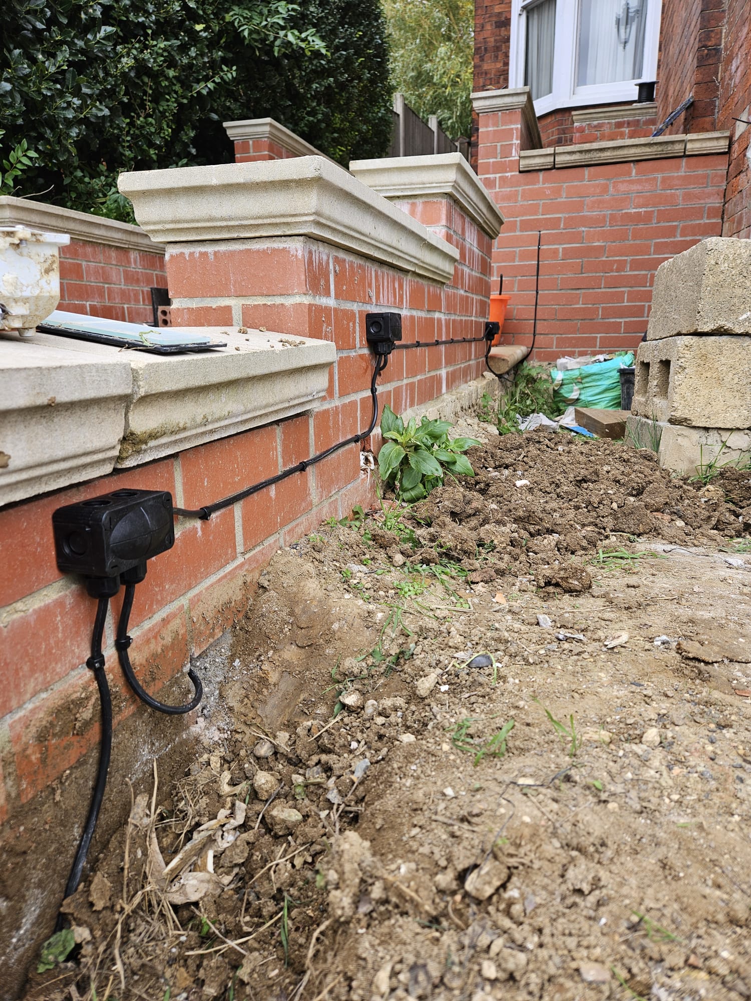 Outdoor wall lights mounted on a Victorian brick boundary wall